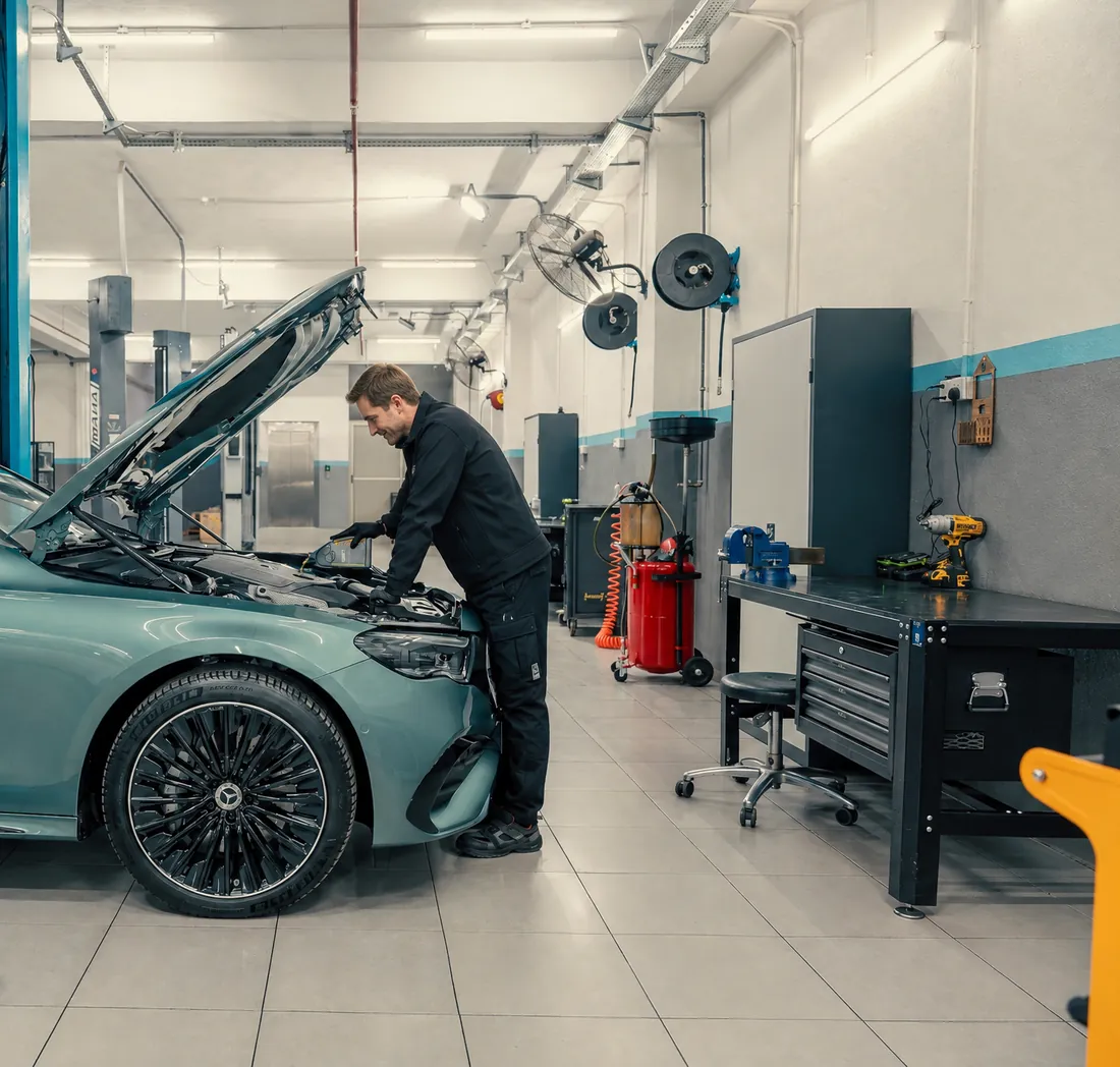 Helle, aufgeräumte Werkstatt mit Hebebühne und einem Fahrzeug bei der Inspektion
